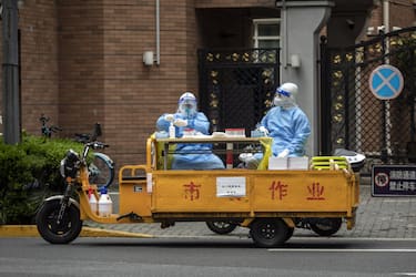 Workers in personal protective equipment (PPE) sits on a rickshaw converted into a mobile Covid-19 testing station during a lockdown in Shanghai, China, on Monday, April 25, 2022. Shanghai, the epicenter of China's worst outbreak since Wuhan more than two years ago, reported 51 fatalities on Sunday, taking deaths in the current wave to 138. Source: Bloomberg
