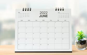 Monthly dest calendar on table in the bright room or modern office  for 2022 year.  side view