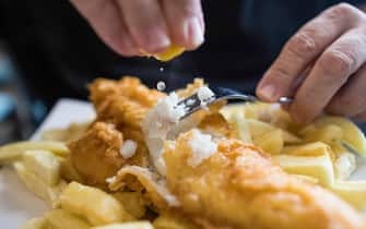 A customer squeezes a lemon over a cod on a plate of fish and chips at a restaurant in Deal, U.K., on Thursday, Oct. 15, 2020. Germany put pressure on France to back down on its demands over fishing, one of the biggest obstacles to a post-Brexit trade deal with the U.K., as Boris Johnson warned he is “disappointed” about the progress of the negotiations. Photographer: Chris Ratcliffe/Bloomberg