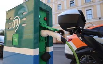 A charging plug connects an electric motorbike to a Mosenergo PJSC vehicle charging point in Moscow, Russia, on Wednesday, Aug. 18, 2021. The combined market forces are achieving something in Russia that government policies and technological advances hope to bring about in the rest of the world — making battery-powered cars more affordable than their gas-powered counterparts. Photographer: Andrey Rudakov/Bloomberg