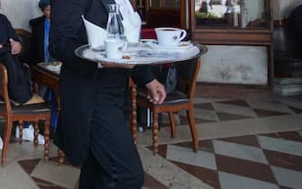 Personale dello storico Caffè Florian impegnato nel servizio ai tavoli all’aperto, oggi 1 maggio 2021. ANSA/ANDREA MEROLA                               