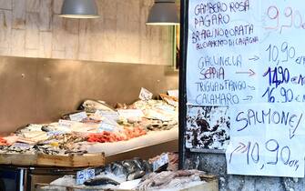 Una famiglia osserva il pesce esposto in una pescheria del centro storico di Genova, 4 marzo 2021. La povertà assoluta torna a crescere e tocca il record dal 2005, secondo le prime stime preliminari dell'Istituto nazionale di statistica (Istat) del 2020. Il fenomeno aumenta sia in termini familiari con oltre 2 milioni di famiglie coinvolte, sia in termine di individui che si attestano a 5,6 milioni. Nell'anno della pandemia i miglioramenti del 2019 sono stati azzerati. ANSA/LUCA ZENNARO