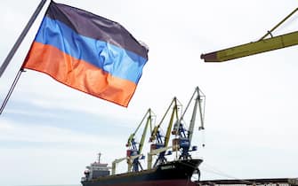A photograph shows a Donetsk People Republic's flag in front of a ship in the harbour of  Mariupol on June 3, 2022, on the 100th day of the Russian military action in Ukraine. - Ukrainian President Volodymyr Zelensky vowed victory on June 3, 2022, even as Russian troops pounded the eastern Donbas region. (Photo by STRINGER / AFP) (Photo by STRINGER/AFP via Getty Images)