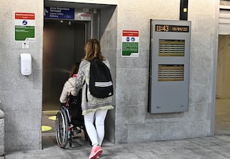 Una donna accudisce un disabile in carrozzina, Genova, 19 aprile 2022.
ANSA/LUCA ZENNARO