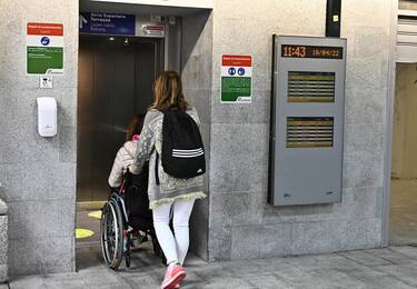 Una donna accudisce un disabile in carrozzina, Genova, 19 aprile 2022.
ANSA/LUCA ZENNARO