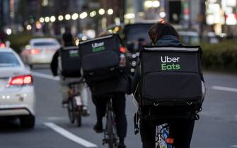 TOKYO, JAPAN - APRIL 11: Uber Eats delivery men ride bicycles through the Kabukicho entertainment area on April 11, 2020 in Tokyo, Japan. Tokyo Governor Yuriko Koike has requested that businesses including schools, athletic facilities, bars and restaurants to temporarily close or operate under reduced hours. The action follows a state of emergency that covers 7 of Japans 47 prefectures as the Covid-19 coronavirus outbreak continues to spread throughout the country. (Photo by Tomohiro Ohsumi/Getty Images)