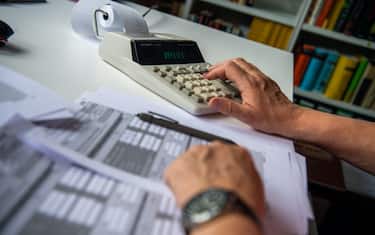 29 May 2021, North Rhine-Westphalia, Bad Oeynhausen: ILLUSTRATION - A pensioner fills out his tax return and types numbers into a desk calculator to calculate it. The Federal Fiscal Court will announce rulings in two cases on pension taxation on Momtag (31.05.2021). The issue is whether the federal government is wrongly taxing pensions twice. (to "Federal Fiscal Court announces pension rulings - major effects possible") Photo: Lino Mirgeler/dpa (Photo by Lino Mirgeler/picture alliance via Getty Images)
