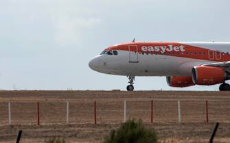 epa09382216 An EasyJet airplane lands in Menorca's airport, Balearic islands, Spain, 31 July 2021. The Balearic islands are recording a high increase in air traffic with lots of national and international flights due to the first weekend of August.  EPA/David Arquimbau Sintes