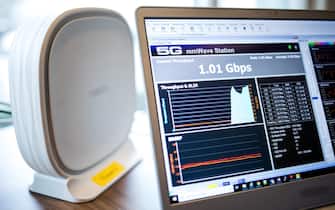 07 February 2019, Hamburg: An antenna receiving unit with 5G modem (Fixed Wireless Access FWA) stands next to a laptop on which a speed test indicates a download rate of 1.01 Gigabit per second (Gbps). Shortly before the completion of a test of high-speed Internet connections based on 5G technology in Hamburg, Telefónica Germany has drawn a positive interim balance. With 5G frequencies in the 26 GHz band used for the first time in this test, it is possible to surf the Internet at lightning speed with several gigabits per second. Photo: Christian Charisius/dpa