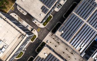 1355498114 Aerial view of solar panels on manufacturing factory building roof at Shanghai free trade zone,China.