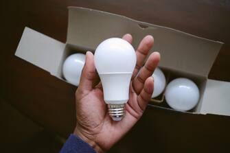 High angle view of unrecognizable black woman holding new LED light bulb
