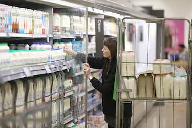 An employee restocks a refrigerator cabinet with cartons of fresh milk inside a Waitrose Ltd. supermarket in the Hove district of Brighton, U.K., on Tuesday, Jan. 27, 2015. Britain has outperformed its neighbors, with the fastest economic growth in the Group of Seven industrialized nations. Photographer: Simon Dawson/Bloomberg via Getty Images