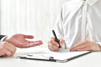 Woman signing contract and business man's hand