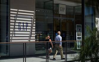 LOS ANGELES, CA - SEPTEMBER 20: People walk by the Gap retail store in Century City on September 20, 2022 in Los Angeles, California.  Gap Inc. is set to cut about 500 corporate jobs as the clothing retailer faces cutbacks due to declining sales, as well as Kanye West ending Yeezy's partnership with Gap Inc. (Photo by Allison Dinner/Getty Images)
