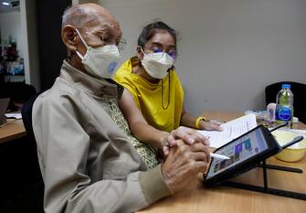 THAILAND PHOTO ESSAY AGING SOCIETY epa09941845 (13/24) Thai 94-year-old Yongyuth Napasab (L) is accompanied by his caregiver learning how to use Canva, a photo and video editor application on tablet for social networking at the OPPY (Old People Playing Young) Club in Bangkok, Thailand, 25 April 2022 (issued 12 May 2022). But also new technology skills are needed for old people nowadays. Since its establishment in 2000, the OPPY (Old People Playing Club) launched computer and related technology learning classes for elderly people to educate basic computer literacy to encourage seniors to use smartphones, tablets, applications, social networks, and new technologies. Yongyuth Napasab, 95-year-old, is the oldest student. He came to the class to learn how to use Canva, a photo and video editor application on a tablet aimed to be used for his social media to connect with senior friends, family members and also celebrate his 95th birthday anniversary with elderly fellows. EPA/RUNGROJ YONGRIT ATTENTION: For the full PHOTO ESSAY text please see Advisory Notice epa...