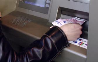 Una donna preleva dei contanti a un bancomat