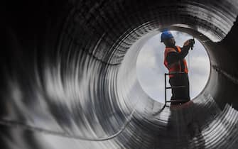17 January 2019, Brandenburg, Klosterdorf: A worker is grinding a pipe on the construction site of the European Gas Link Pipeline (EUGAL).  The gas route of the gas network operator Gascade is to be almost 500 kilometers long and from the end of 2019 will primarily transport Russian natural gas from the Baltic Sea through the federal states of Mecklenburg-Western Pomerania, Brandenburg and Saxony to the Czech Republic.  Brandenburg accounts for the largest section with about 270 kilometers.  Each individual pipe is about 18 meters long, weighs about 15 tons and has a diameter of 1.40 meters.  Photo: Patrick Pleul/dpa-Zentralbild/ZB