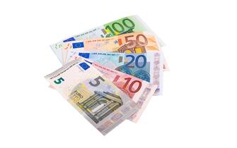 Euro banknotes of different denominations lie in a fan isolated on a white background close-up