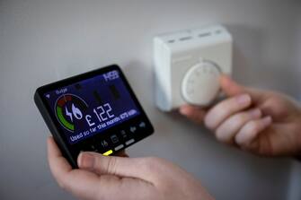 epa10381596 A smart energy meter, used to monitor gas and electricity use and a central heating thermostat dial at a home in London, Britain, 29 December 2022.  Britain's major energy suppliers will increase their electricity unit prices from 01 January 2023 in line with Office of Gas and Electricity Markets (Ofgem) price cap.  EPA/TOLGA AKMEN