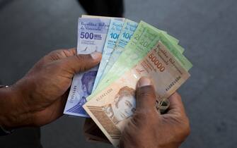 A person holds bolivar banknotes. Photographer: Manaure Quintero/Bloomberg