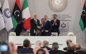 1246612299 Italian multinational oil and gas company ENI's CEO Claudio Descalzi (front L) and Libyan National Oil Corporation chief Farhat Bengdara (front R) sign a bilateral agreement during a ceremony attended by Italy's Prime Minister Giorgia Meloni (back C) and Libya's Tripoli-based Prime Minister Abdulhamid Dbeibah (back R) in the Libyan capital, on January 28, 2023. - Meloni arrived in the Libyan capital Tripoli for talks on energy as well as the thorny issue of migration, Libyan state media said. (Photo by Mahmud Turkia / AFP) (Photo by MAHMUD TURKIA/AFP via Getty Images)