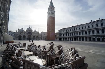 I tavolini e le sedie dello storico Caffè Quadri , che oggi 18 maggio 2020, non riapre, accatastati in piazza San Marco. ANSA/ANDREA MEROLA