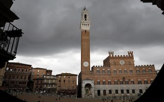 epa07132598 General view of the Torre del Mangia tower at the Piazza del Campo (Campo Square) in the historic center of Siena, Tuscany, Italy, 26 October 2018 (issued 31 October 2018). The city's historic center has been declared by UNESCO a World Heritage Site and is one of the nation's most visited tourist attractions.  EPA/ABIR SULTAN
