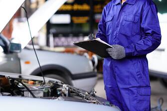 Automotive mechanic doing maintenance checklist and estimated repair, Commercial vehicle maintenance checklist.