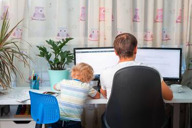 Father with kid trying to work from home during quarantine. Stay at home, work from home concept during coronavirus pandemic