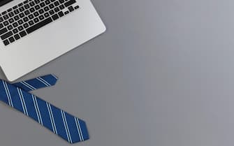 Fathers day concept with blue dress tie and laptop computer on a gray background in flat lay format