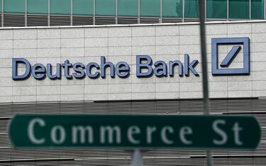 epa08777179 The logo of German bank Deutsche Bank above a road sign in the financial district of Singapore, 27 October 2020. The fallout of the global Covid-19 coronavirus pandemic has had a range of effects across workers from different sectors of the economy. As businesses gradually open up, economists are describing a 'K-shaped' recovery caused by lower wage workers affected by health and safety regulations, while white collar workers remain largely unaffected due to the advent of telecommuting and work from home arrangements.  EPA/WALLACE WOON