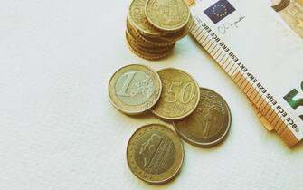 Concept of euro banknotes and coins at white background. European currency. Coins of 1 euro, 2 euro and cents. 50 euro banknotes