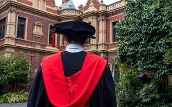 A foreign student in a graduation gown at Melbourne University, Parkville,  Melbourne, Australia.