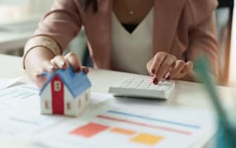 Businesswoman working doing finances and calculation cost of real estate investment while be signing to contract, Concept mortgage loan approval