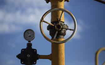 A pressure gauge and valve wheel on yellow pipework at a gas facility. Photographer: Oliver Bunic/Bloomberg