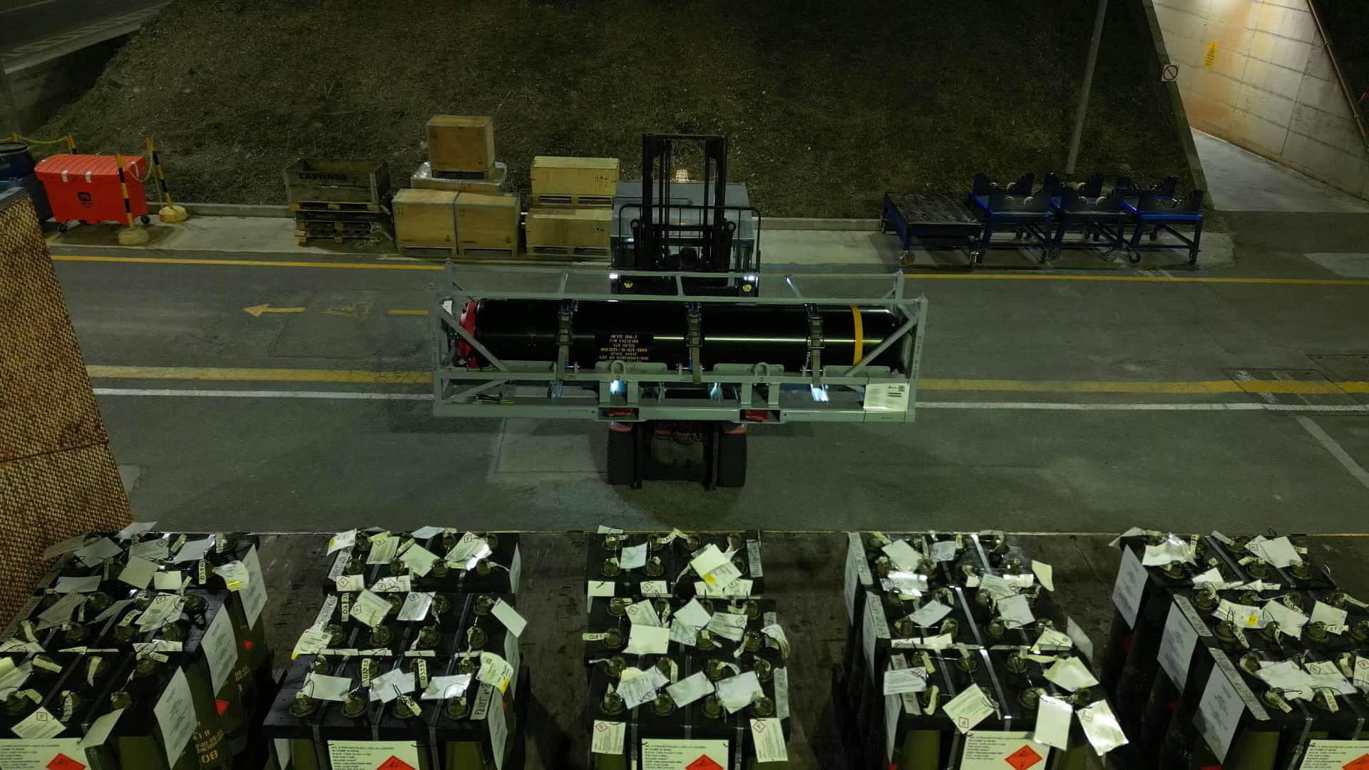 Una mina marina viene caricata su un camion di notte