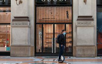 MILAN, ITALY - JUNE 02: A tourist rides a segway hoverboard as he passes in front of a Gucci store on June 02, 2020 in Milan, Italy. Many Italian businesses have been allowed to reopen, after more than two months of a nationwide lockdown meant to curb the spread of Covid-19. (Photo by Roberto Finizio/Getty Images)