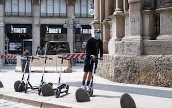 MILAN, ITALY - MAY 08: A passer-by after having just rented a kick scooter supplied by the Municipality of Milan on May 08, 2020 in Milan, Italy. Italy was the first country to impose a nationwide lockdown to stem the transmission of the Coronavirus (Covid-19), and its restaurants, theaters and many other businesses remain closed. (Photo by Roberto Finizio/Getty Images)