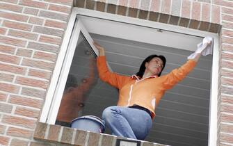 976698544 A young woman cleaning windows. (Photo by plus49/Construction Photography/Avalon/Getty Images)
