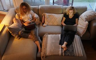 1215455742 BERLIN, GERMANY - MARCH 28: A mother, who is temporarily working from home, and her daughter, home after her university was temporarily closed, sit on a couch at their laptop computers at their home during the coronavirus crisis on March 28 in Berlin, Germany.The coronavirus and the disease it causes, COVID-19, are having a fundamental impact on society, government and the economy in Germany. Public life has been restricted to the essentials in an effort by authorities to slow the spread of infections. Hospitals are scrambling to increase their testing and care capacity. An economic recession seems likely as economic activity is slowed and many businesses are temporarily closed. Schools, daycare centers and universities remain shuttered. And government, both federal and state, seek to mobilize resources and find adequate policies to confront the virus and mitigate its impact. (Photo by Sean Gallup/Getty Images)