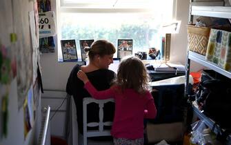 1214750318 NEWCASTLE UNDER LYME, UNITED KINGDOM - MARCH 25: Four-year-old Lois Copley-Jones, who is the photographer's daughter, disturbs her mother Ruth, who is homeworking on the third day of the nationwide school closures on March 25, 2020 in Newcastle Under Lyme, United Kingdom. British Prime Minister, Boris Johnson, announced strict lockdown measures urging people to stay at home and only leave the house for basic food shopping, exercise once a day and essential travel to and from work. The Coronavirus (COVID-19) pandemic has spread to at least 182 countries, claiming over 10,000 lives and infecting hundreds of thousands more. (Photo by Gareth Copley/Getty Images)