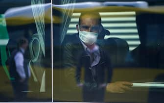 SCHOENEFELD, GERMANY - APRIL 09: A seasonal worker from Romania wears a protective mask as he sits in a bus after arriving with others on a chartered flight at Schoenefeld Airport during the coronavirus crisis on April 09, 2020 in Schoenefeld, Germany. The German government initially imposed a ban on seasonal workers coming from abroad as part of measures to stem the spread of the coronavirus. The restriction was recently relaxed and workers are now arriving on special flights and undergo health checks upon their arrival. The labor-intensive asparagus harvest depends heavily on workers from Romania and Poland. (Photo by Sean Gallup/Getty Images)