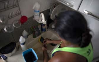 Domestic worker Fabiana Barbosa de Souza, 36, washes the dishes at her house in Sampaio neighborhood, northern Rio de Janeiro, Brazil on January 23, 2019. - The working conditions of domestics in Latin America, to whom director Alfonso Cuaron pays homage in his recent movie 'Roma', is slowly reaching a legal framework. Whilst several countries in the region have established laws for the sector in the last decade, other simultaneous realities such as economic crises and migration, are hampering those conquests and ambitions of formality. (Photo by Mauro Pimentel / AFP)        (Photo credit should read MAURO PIMENTEL/AFP via Getty Images)