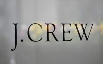 The J.Crew logo is seen at the window of a closed J.Crew store near Rockefeller Plaza on May 4, 2020 in New York City. - US clothing retailer J. Crew filed to begin bankruptcy protection proceedings Monday, after reaching an agreement with major creditors on a $1.65 billion debt restructuring plan, the company said in a statement. The brand, whose clothes have been worn by former first lady Michelle Obama, said online sales operations, which account for more than half its revenues, will continue as normal. (Photo by Angela Weiss / AFP) (Photo by ANGELA WEISS/AFP via Getty Images)