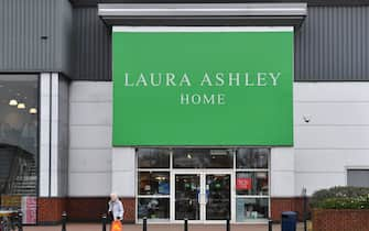 A shopper passes the front entrance of the Laura Ashley womenswear and homewear store in Aintree, Liverpool, north-west England on March 17, 2020. - British clothing and household goods retailer Laura Ashley Holdings collapsed Tuesday, March 17 into administration as rescue talks failed due to coronavirus turmoil, risking up to 2,700 jobs. (Photo by Paul ELLIS / AFP) (Photo by PAUL ELLIS/AFP via Getty Images)