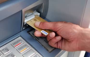 A man takes out Euro banknotes from an automated teller machine (ATM) at a cash point of the French bank "La Banque Postale" in Carquefou, Western France, on September 10, 2014.  AFP PHOTO / JEAN-SEBASTIEN EVRARD        (Photo credit should read JEAN-SEBASTIEN EVRARD/AFP via Getty Images)
