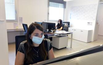 TRENTO, ITALY - MAY 26: Women wearing face masks at work in the headquarters of a construction company on May 26, 2020 in Trento, Italy. Many Italian businesses have been allowed to reopen, after more than two months of a nationwide lockdown meant to curb the spread of Covid-19. (Photo by Alessio Coser/Getty Images)