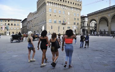 FLORENCE, ITALY - JUNE 03:  Tourists walk in an almost empty Piazza della Signoria the day of the reopening of the Italian borders on June 3, 2020 in Florence, Italy. From today in Italy the borders are reopened and travel  is allowed within Italy between the Regions and between Italy and abroad. But many countries prohibit entry into Italy and from Italy. There have been over 233,000 reported COVID-19 cases in Italy and more than 33,000 deaths.  (Photo by Laura Lezza/Getty Images)