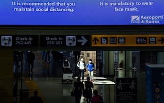 A message on a board advises travelers to maintain social distancing at Rome's Fiumicino airport on June 3, 2020, as airports and borders reopen for tourists and residents free to travel across the country, within the COVID-19 infection, caused by the novel coronavirus. (Photo by Filippo MONTEFORTE / AFP) (Photo by FILIPPO MONTEFORTE/AFP via Getty Images)