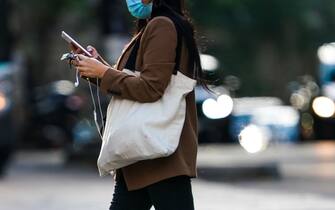 PARIS, FRANCE - JULY 02: A passerby wears a blue protective face mask, a brown blazer jacket, a white tote bag, on July 02, 2020 in Paris, France. (Photo by Edward Berthelot/Getty Images)